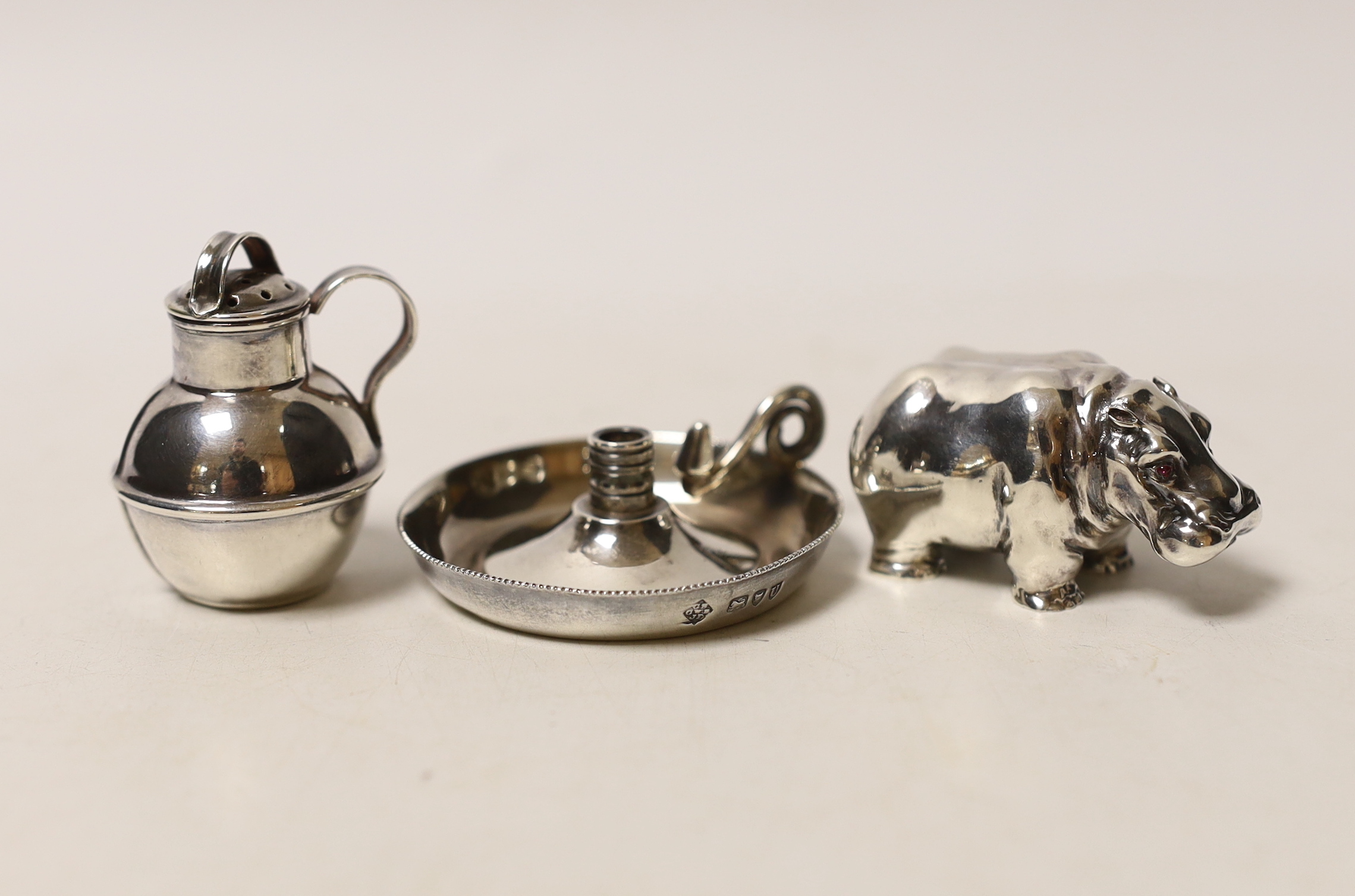 A modern silver miniature model of a hippopotamus, a white metal 'Guernsey can' pepperette and a part of a late Victorian silver small chamberstick.